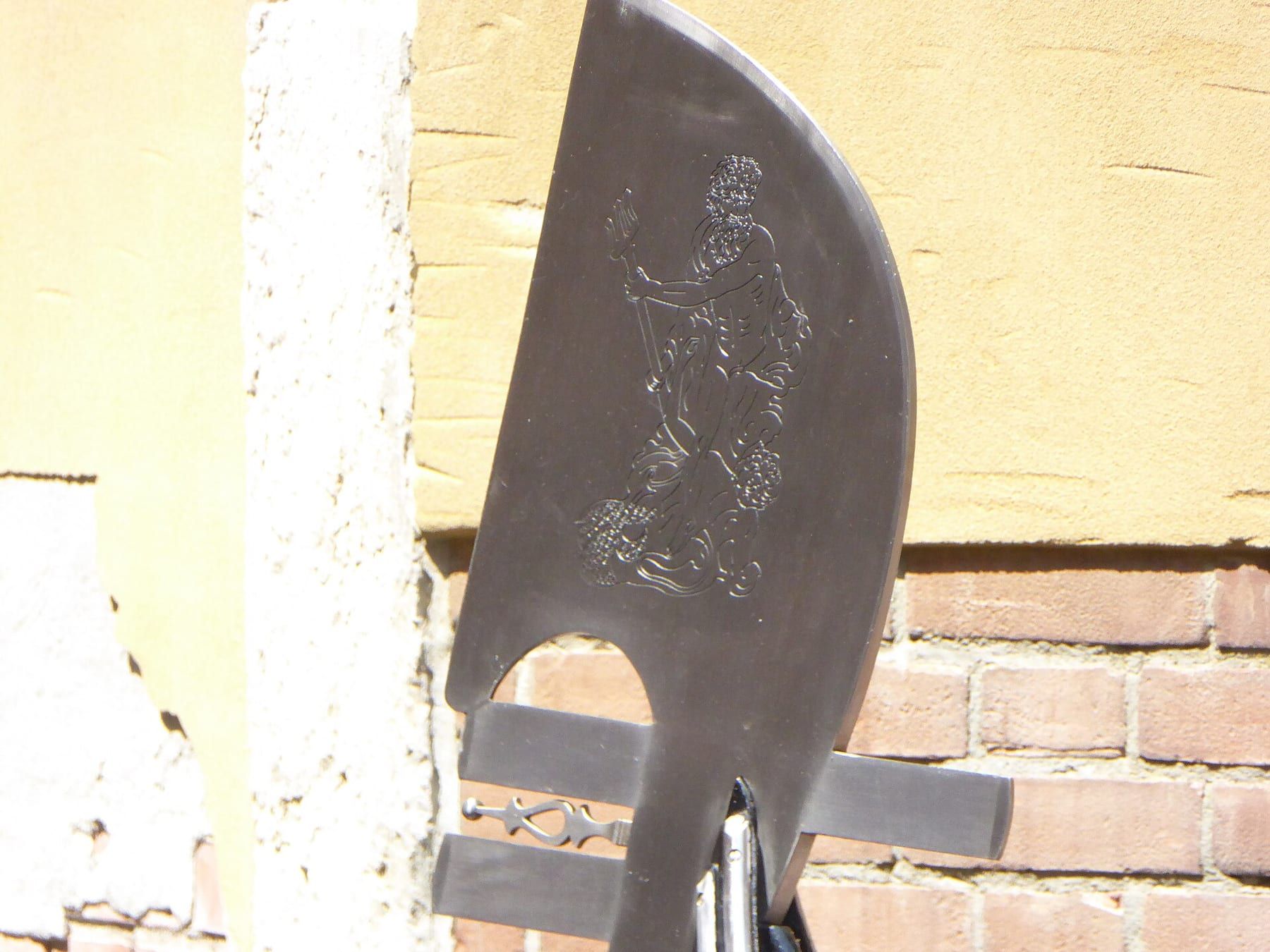 Close-up of a carved walnut forcola oarlock on the side of a gondola, with the wooden oar resting in it