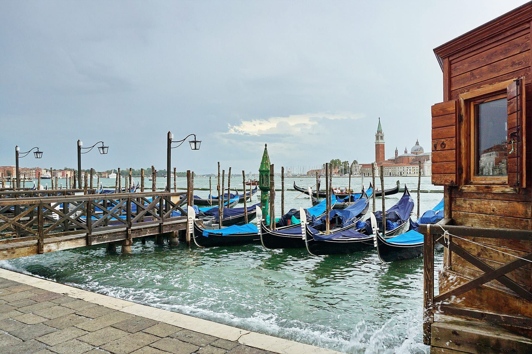 Black gondolas moored in front of the Doge's Palace on the St Mark's waterfront