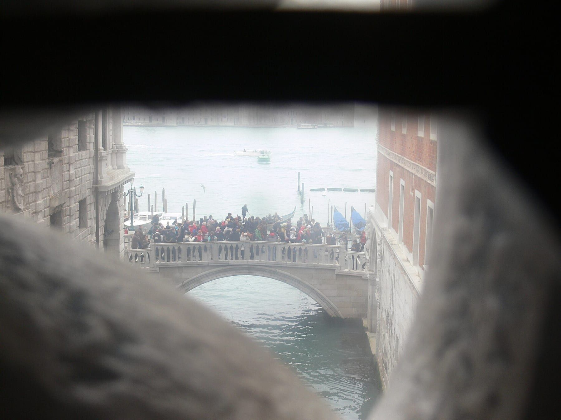 The Bridge of Sighs framed from Ponte della Paglia, gondolas waiting on Rio di Palazzo below