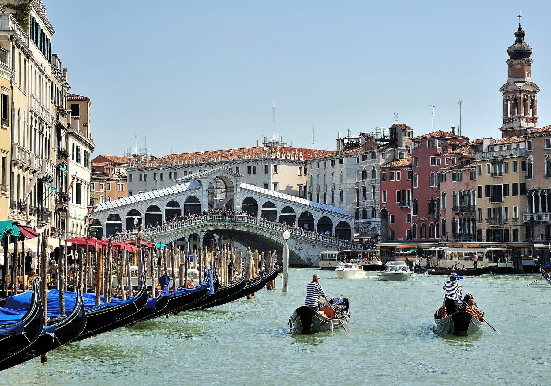 Gondola passing under the stone arch of the Rialto Bridge on the Grand Canal