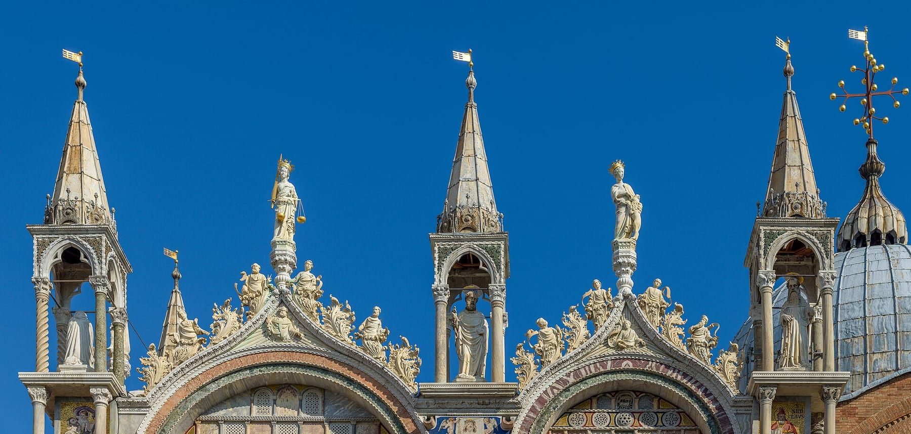Gold mosaics and domes on the façade of St Mark's Basilica in morning light